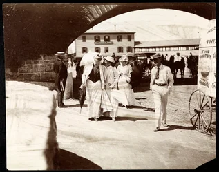 Tres mujeres y un hombre caminando en el muelle de Narragansett con el carrito del fotógrafo itinerante, Rhode Island, 1891